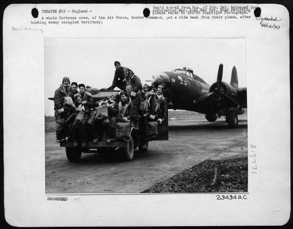 "Masters of the Air" archival photo of airmen in Jeep, plane in background